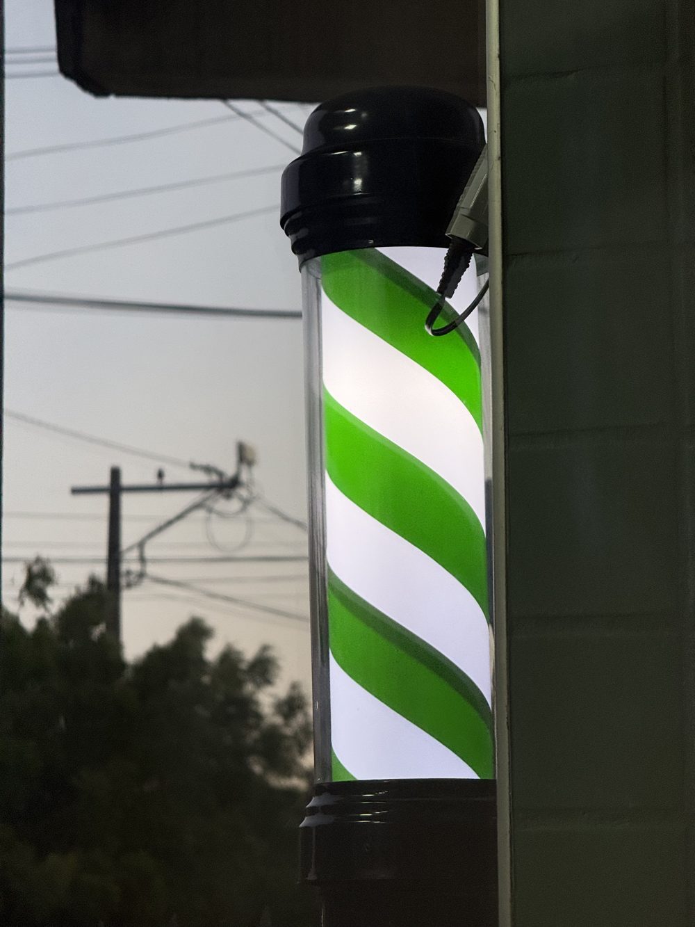 Poste de barbearia listrado de verde e branco